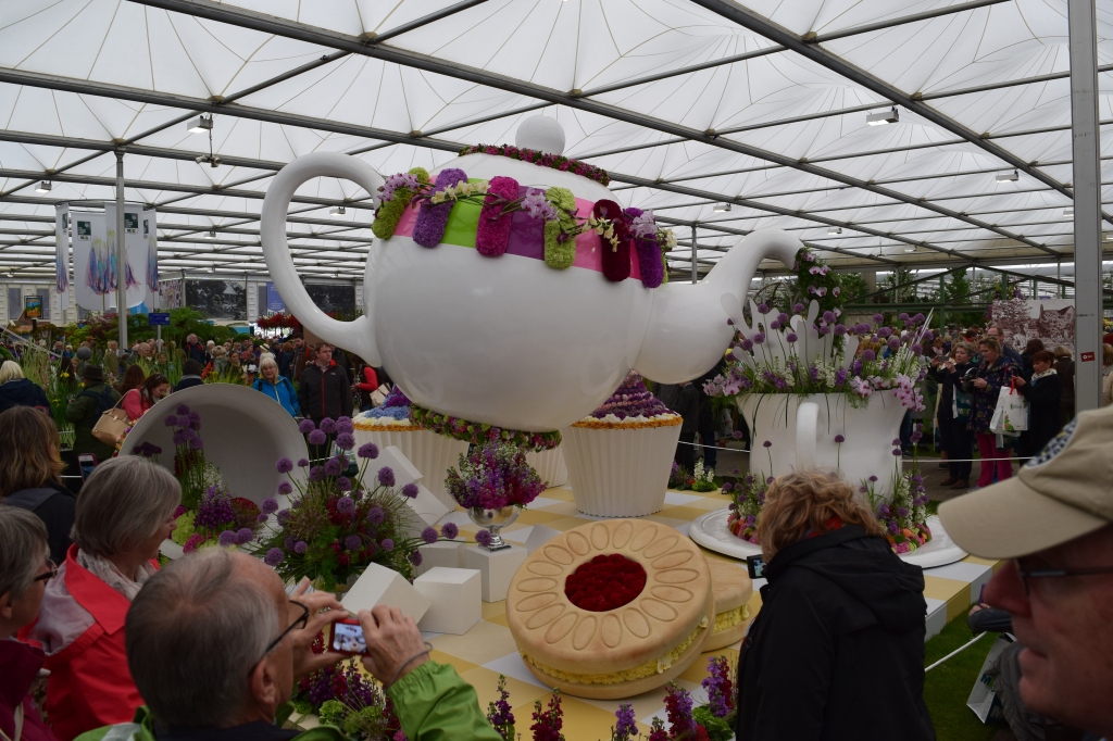 A large tea cup and tea pot with flowers
